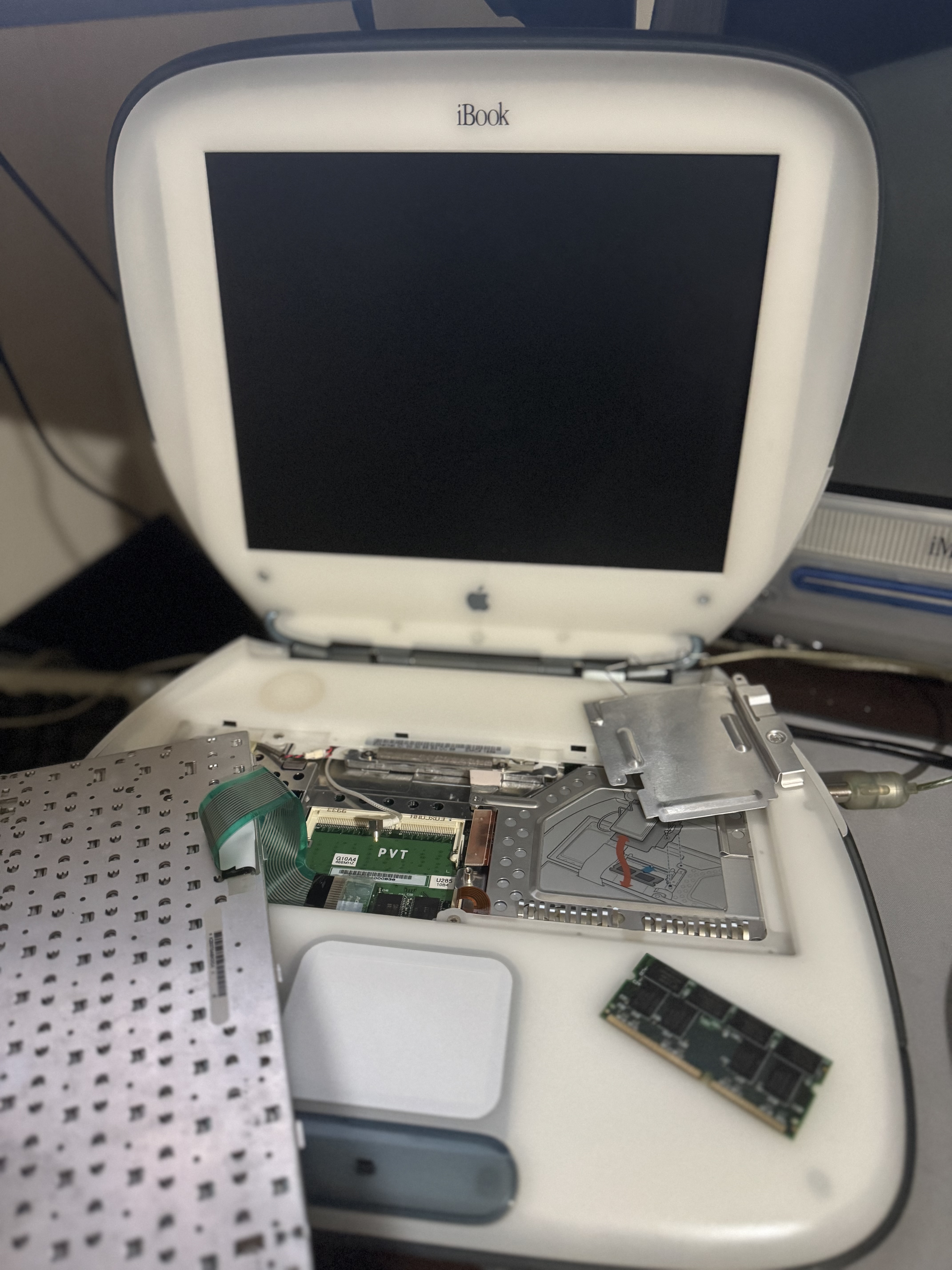 G3 iBook SE — RAM replacement. Mid-upgrade, bottom panel off.